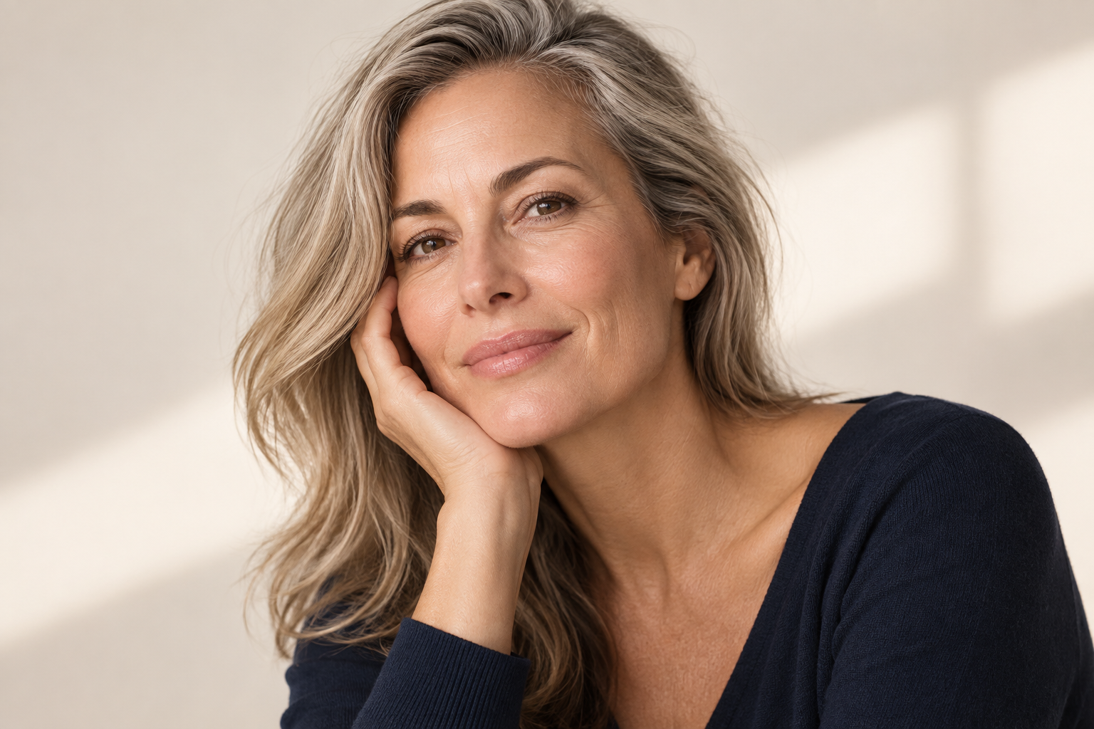 Woman with luminous mature skin and natural makeup representing skincare-infused beauty.